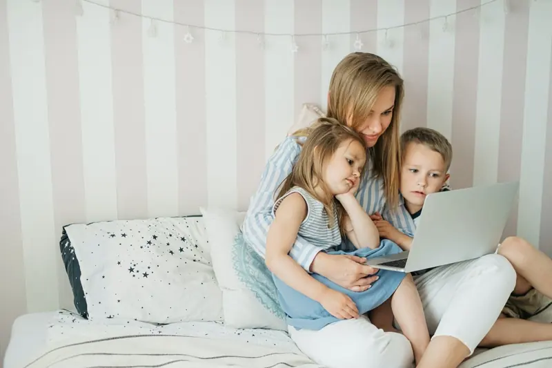 Mutter mit zwei Kindern am Laptop